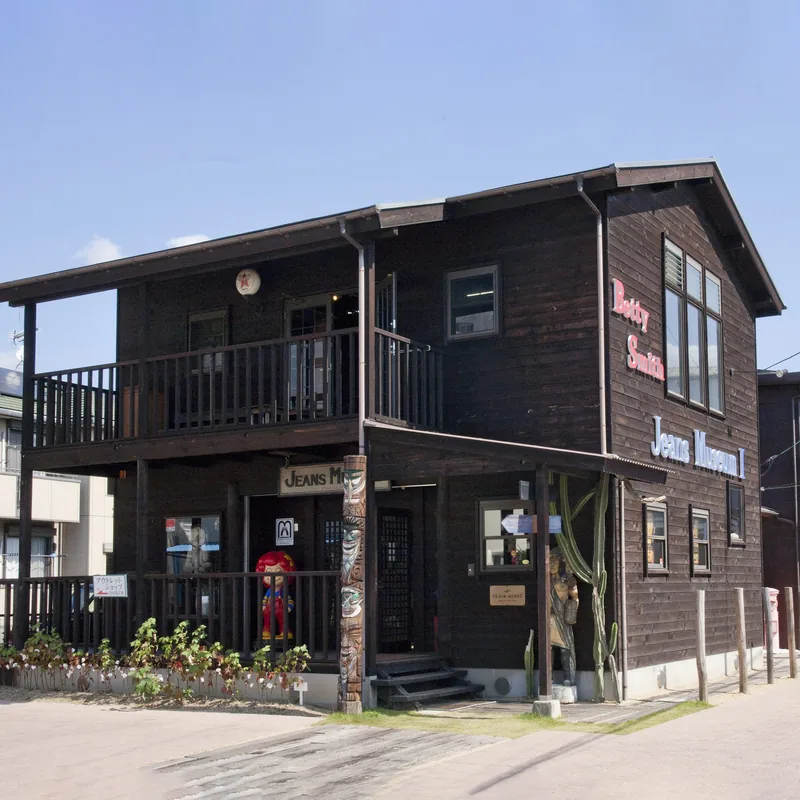 ベティスミス ジーンズミュージアム1号館。焼き杉の板を張った2階建ての建物に「Jeans Museum I」の文字が並ぶ
